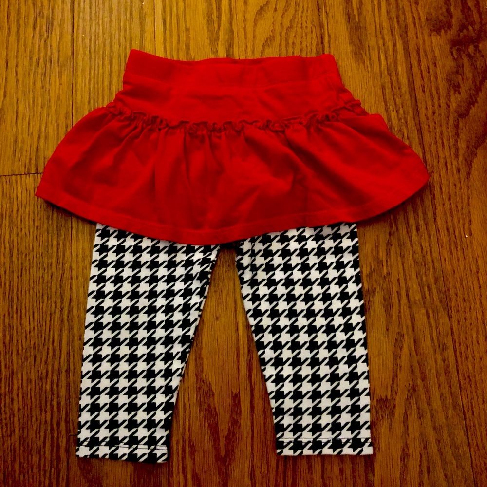 Red cloth tutu attached to black and white pattern leggings